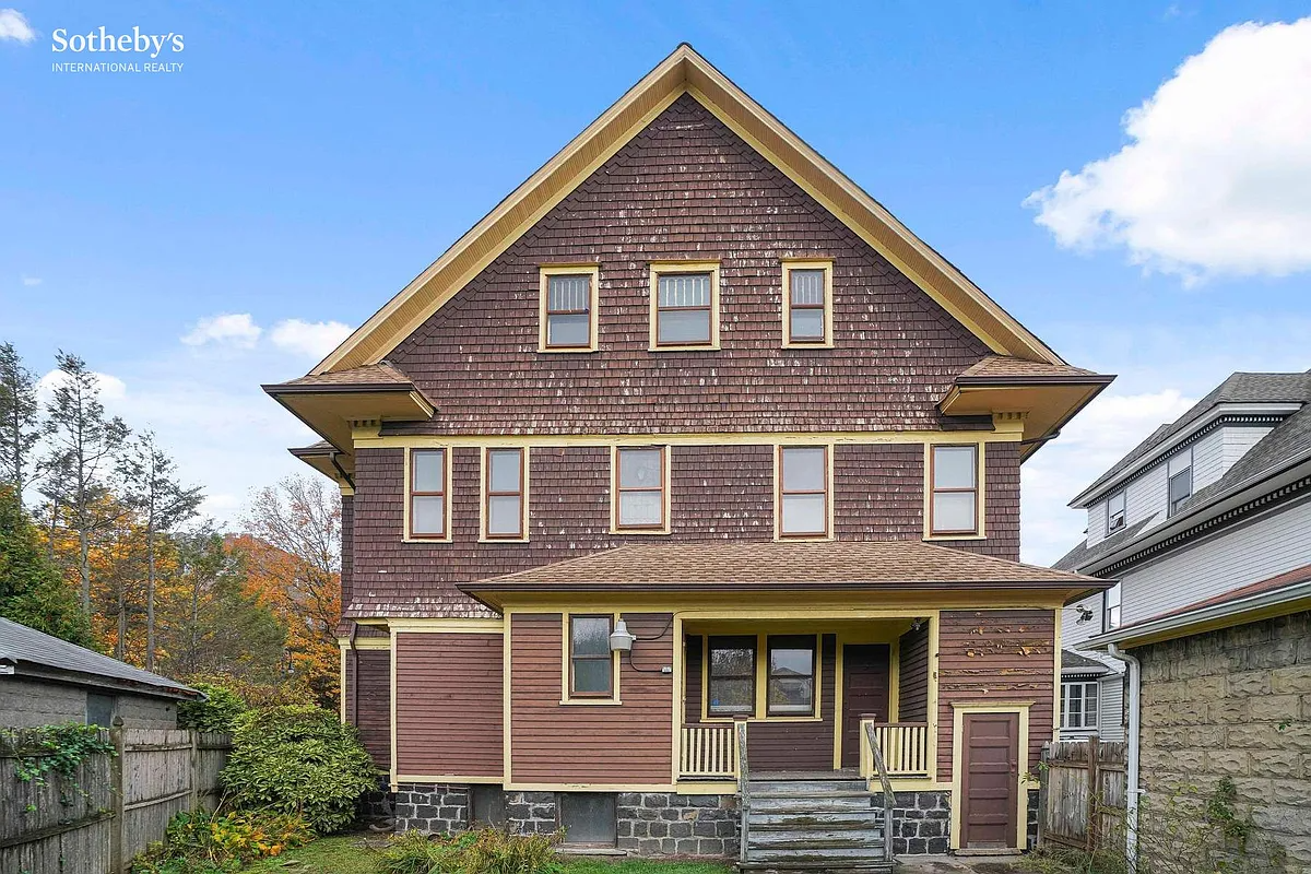 rear facade with brown shingles and siding, yellow trim