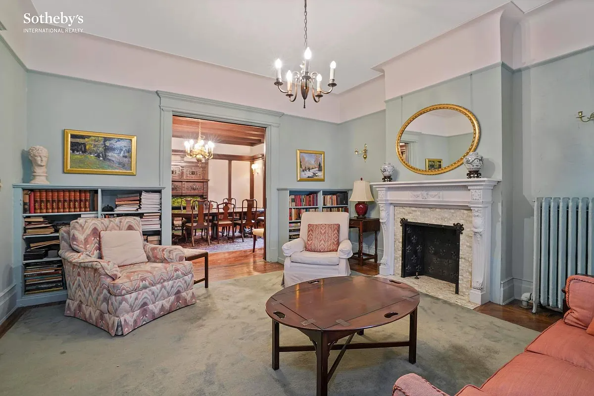 parlor with picture rail, mantel, wood floor