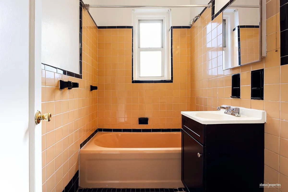 bathroom with peach tile and tub