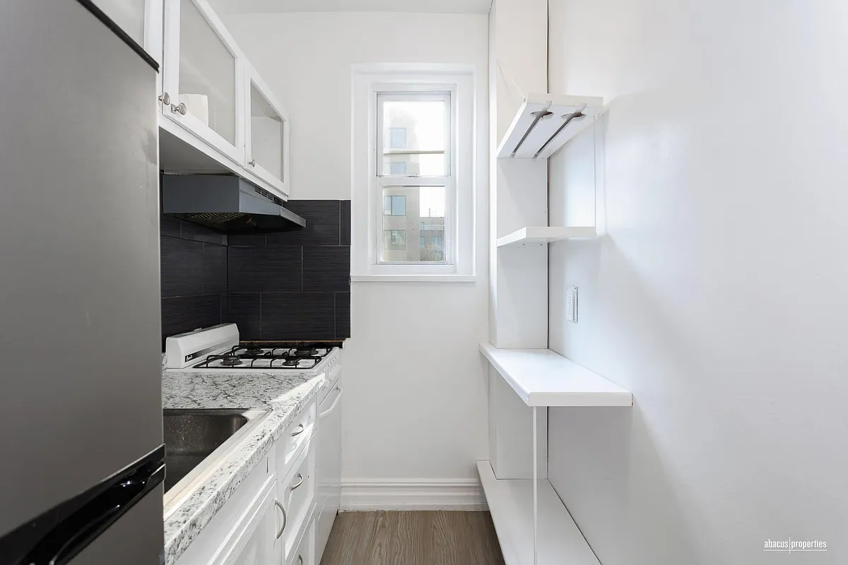 kitchen with white cabinets and black backsplash tile