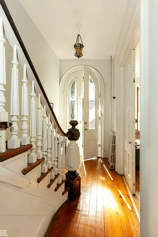 entry with wide planked floorboards, elaborate newel post, stair