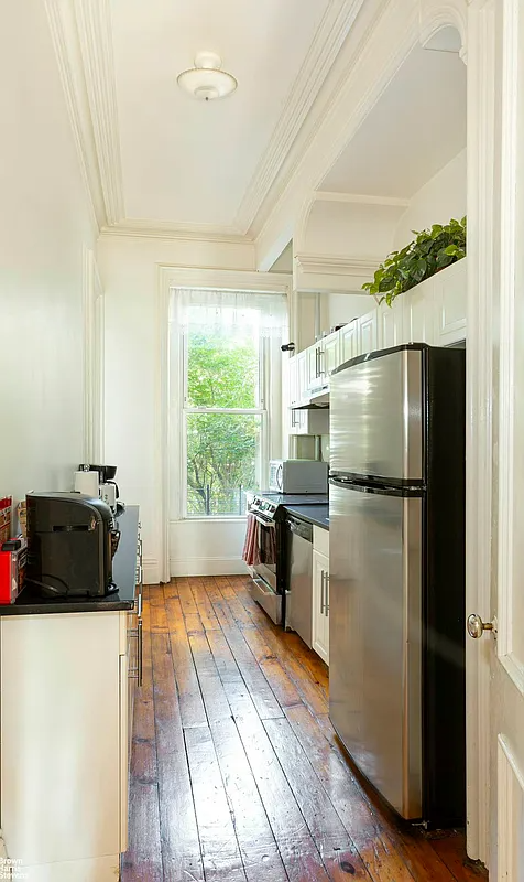kitchen with wood floor, white cabinets