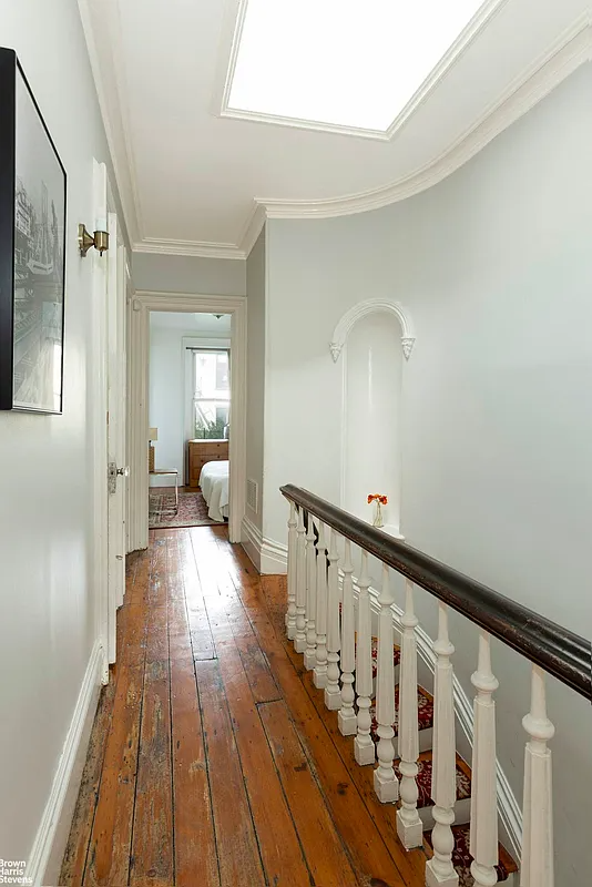 upstairs hallway with wood floors, stair niche