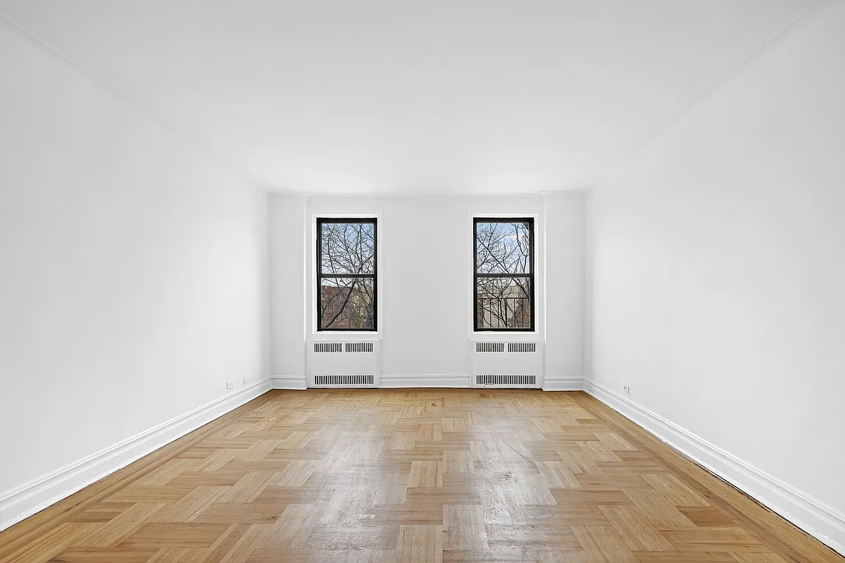 living room with wood floor, white walls, two windows