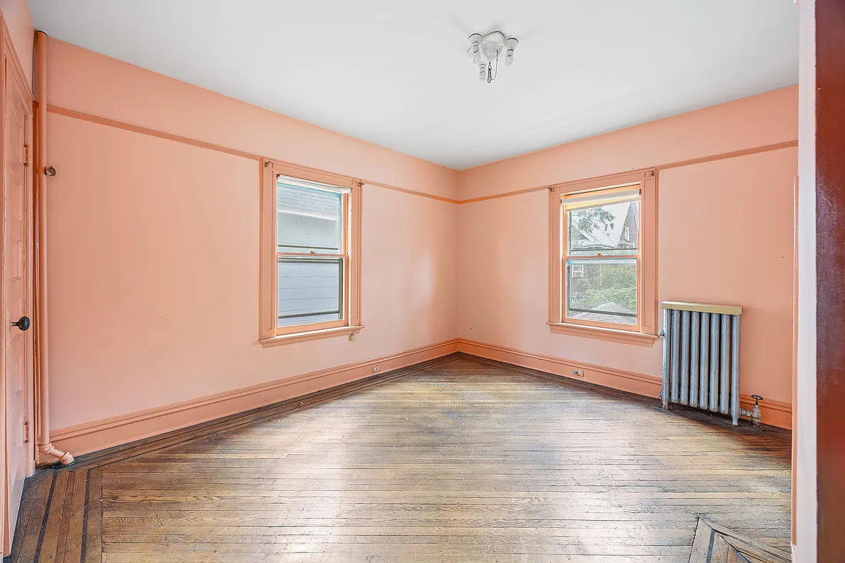 bedroom with peach walls, wood floor