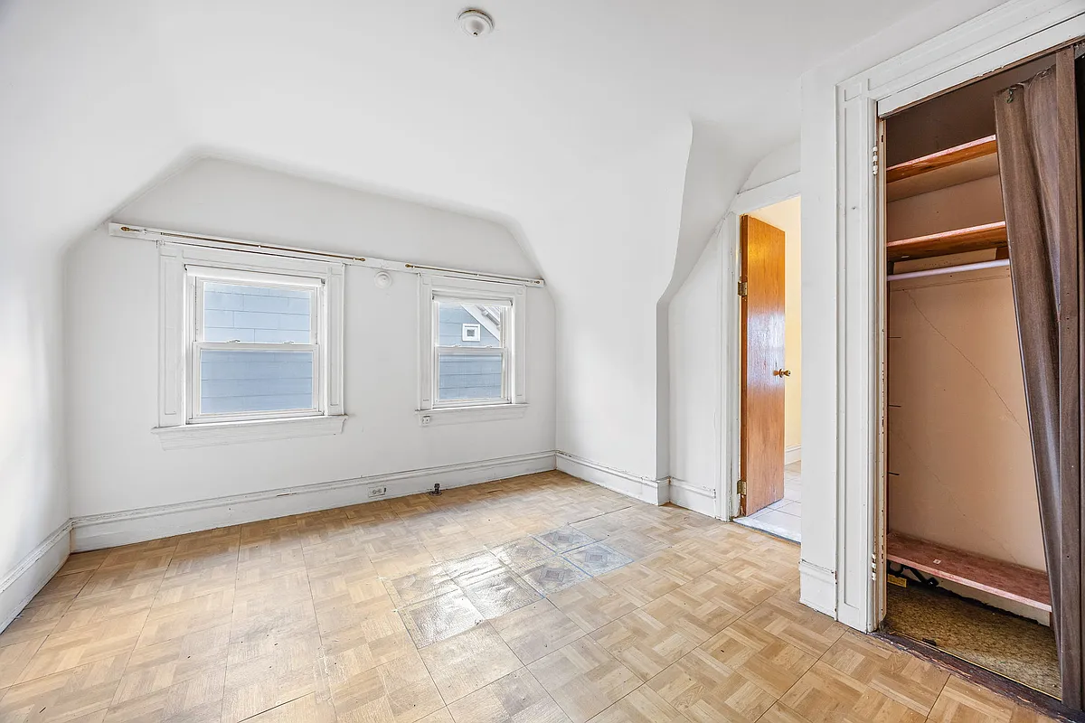 bedroom with white walls, parquet floor