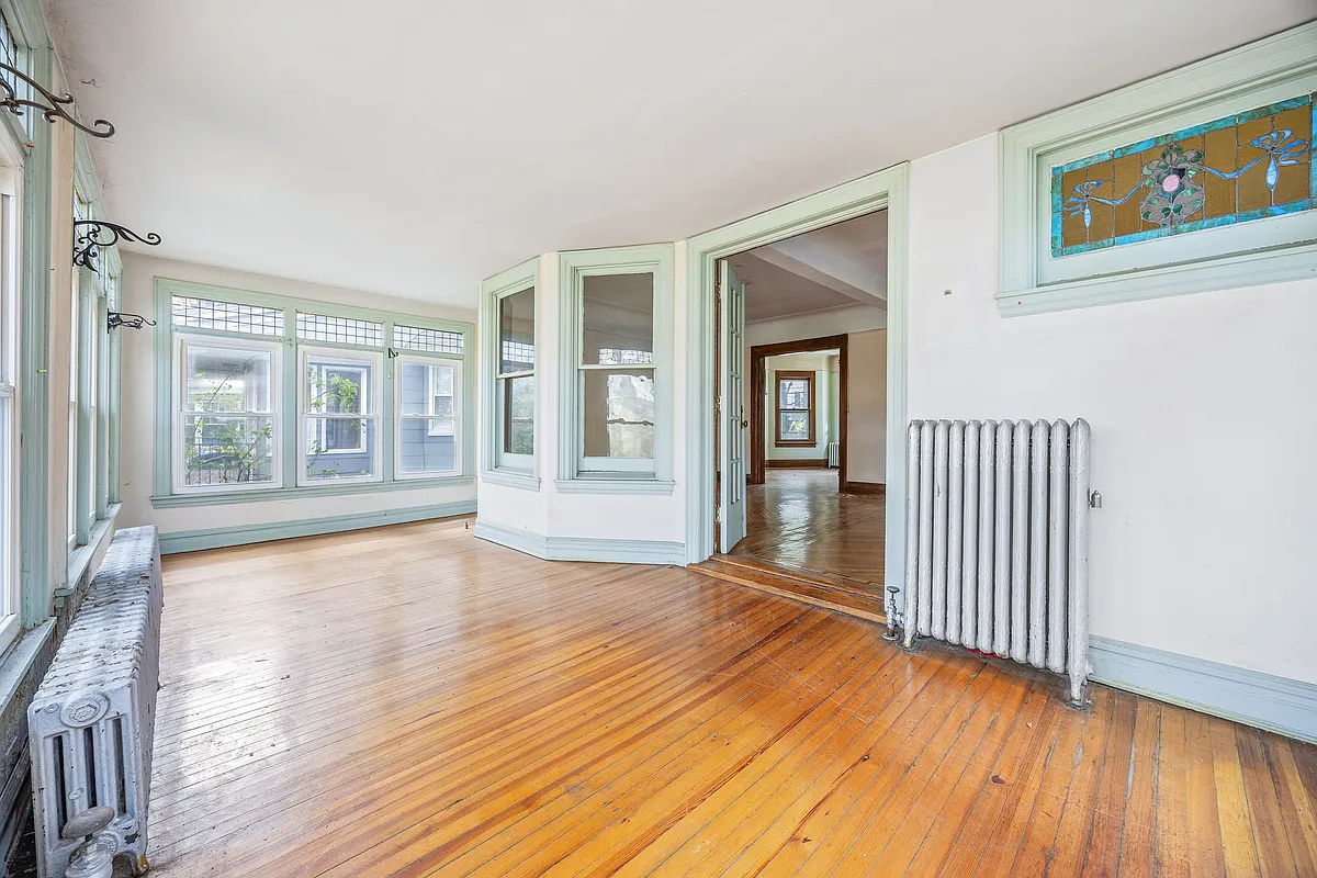 enclosed porch with wood floors, windows on three sides