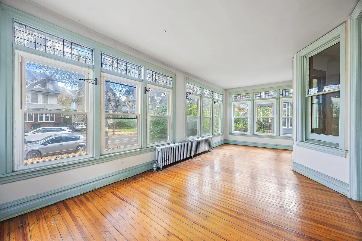 enclosed porch with wood floors, windows on three sides