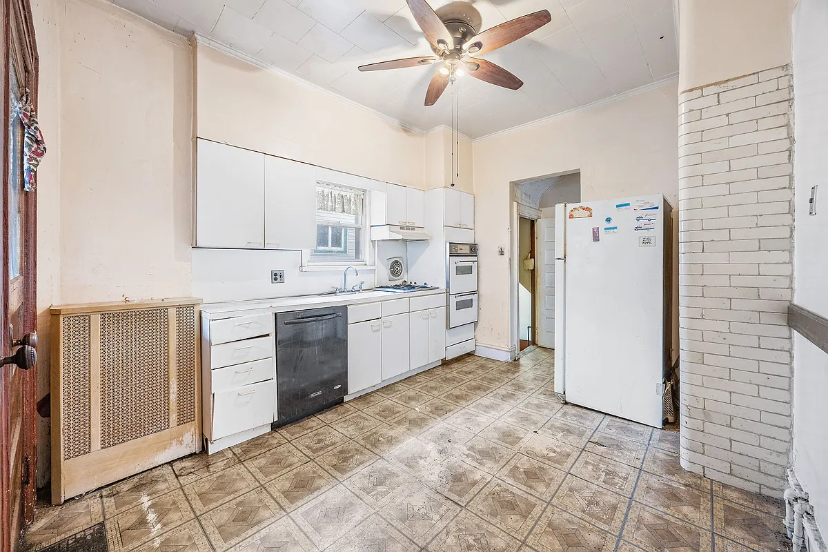 kitchen with white cabinets, subway tile, ceiling fan