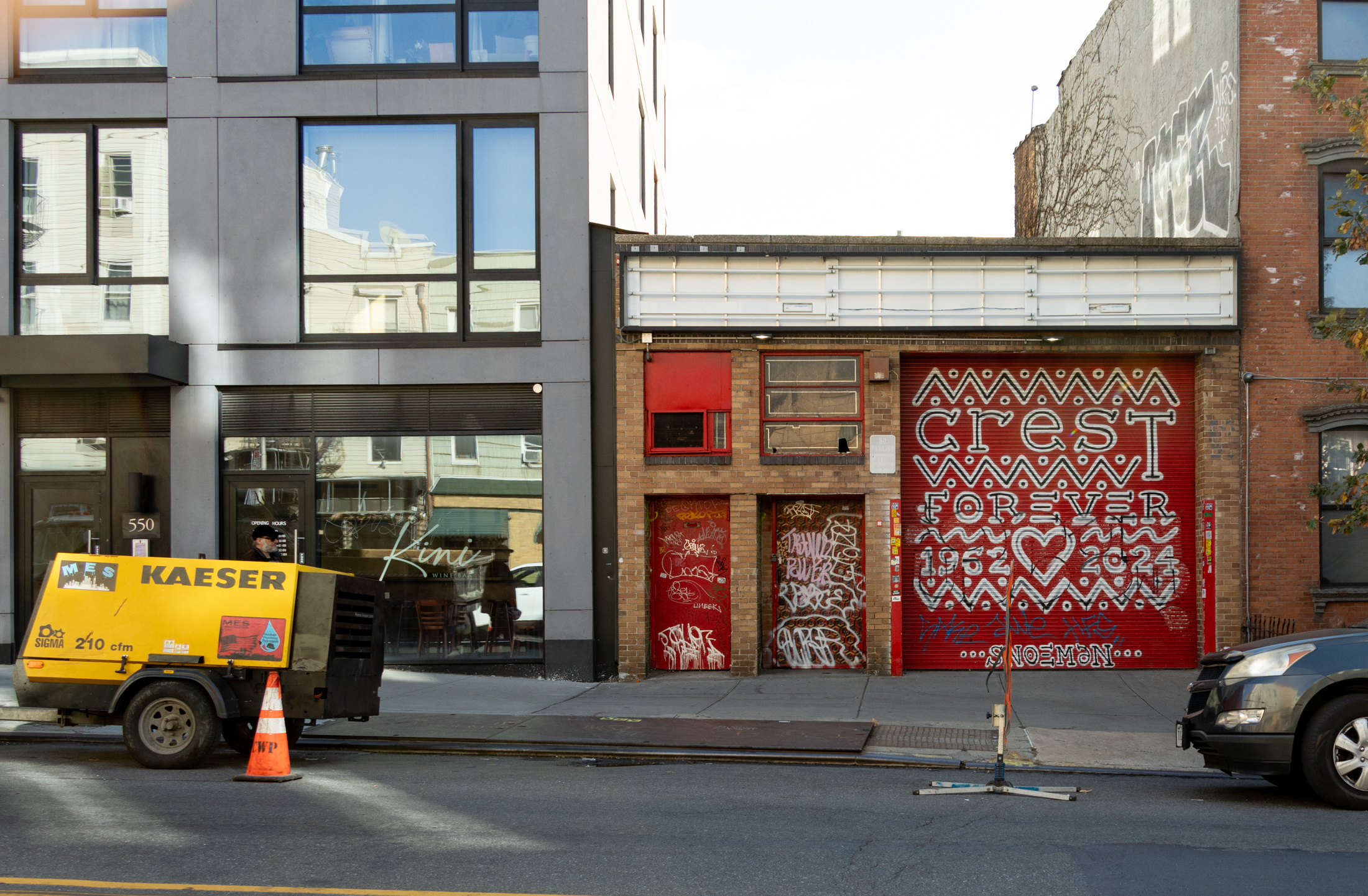 brick garage with crest forever painted on the door
