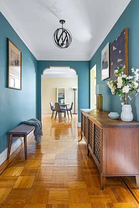 foyer with blue walls, arched doorway to living room