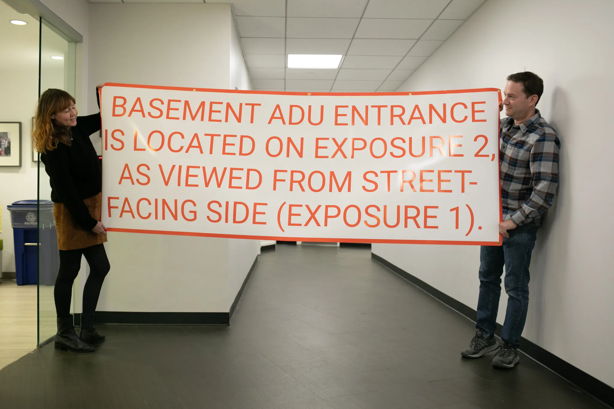 Citizens Housing & Planning Council staff members Sarah Watson and Howard Slatkin created a sign to the specifications in the Department of Building's proposed rules for basement apartment conversions, Dec. 3, 2025.