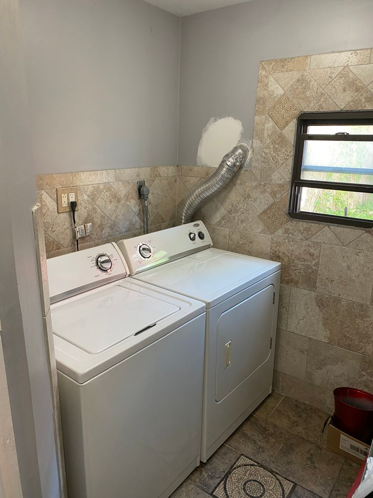 laundry room with beige tile