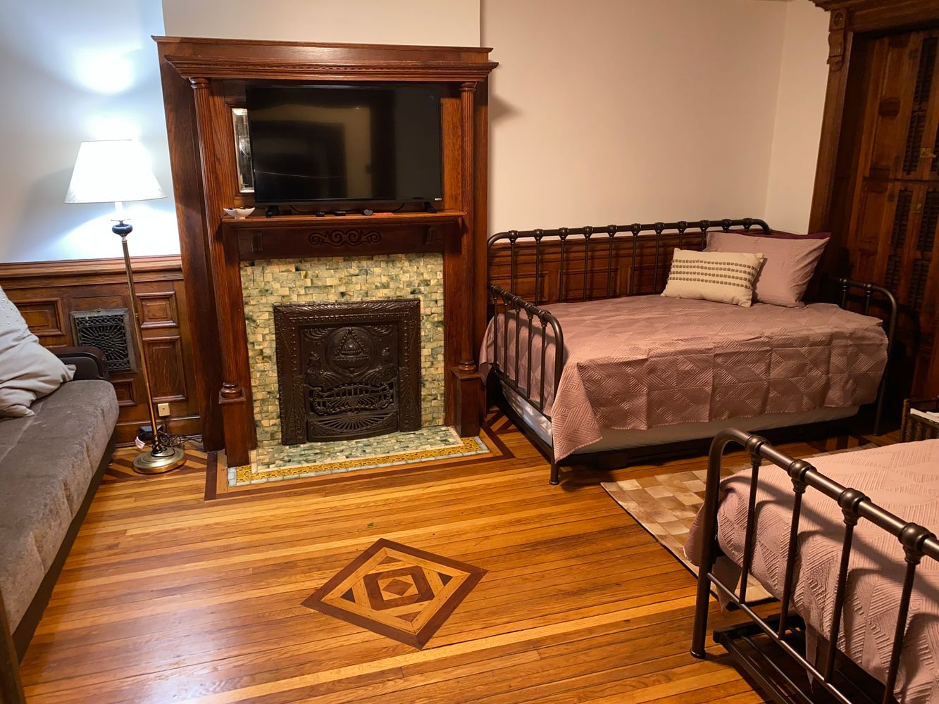 bedroom with mantel, wood floor