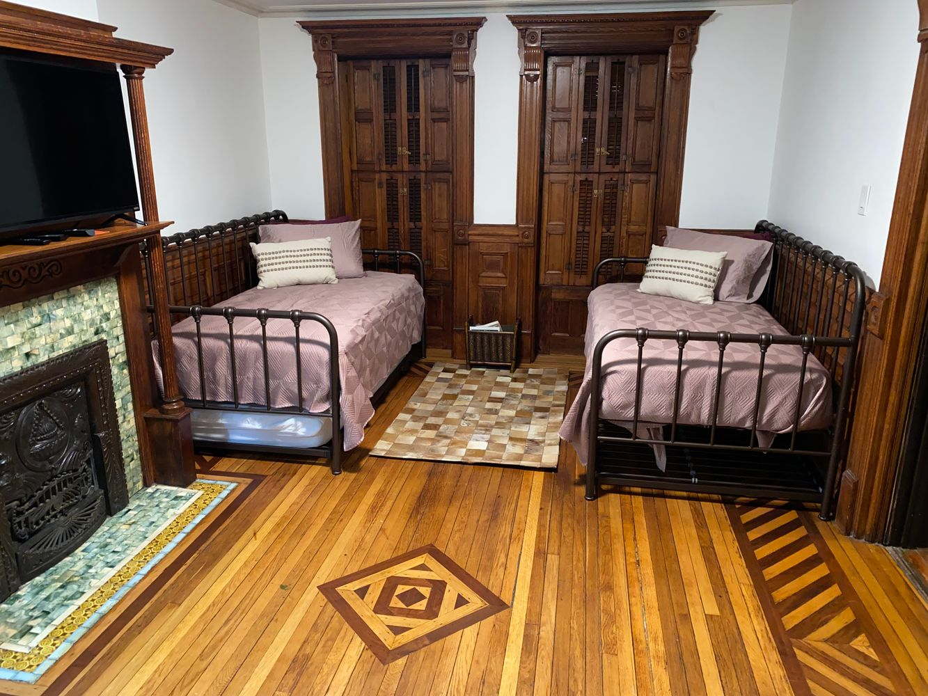 bedroom with mantel, wood floor