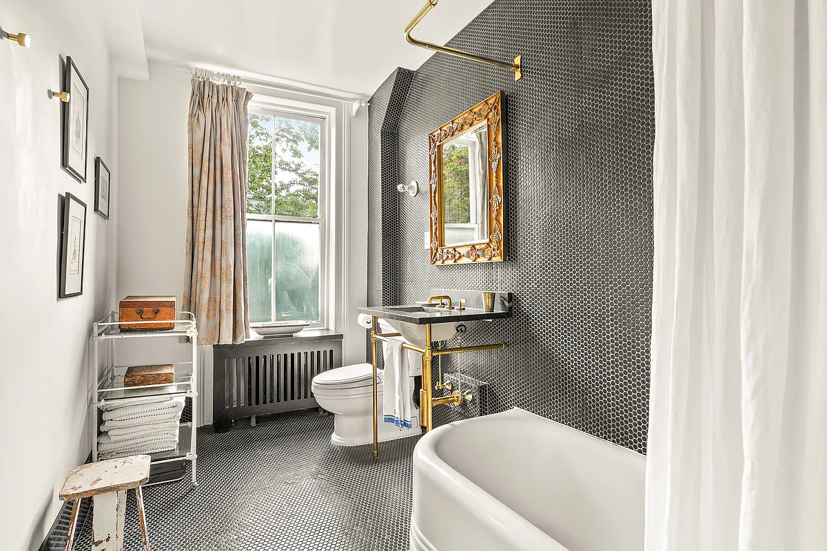 bathroom with black penny tile on floor and one wall