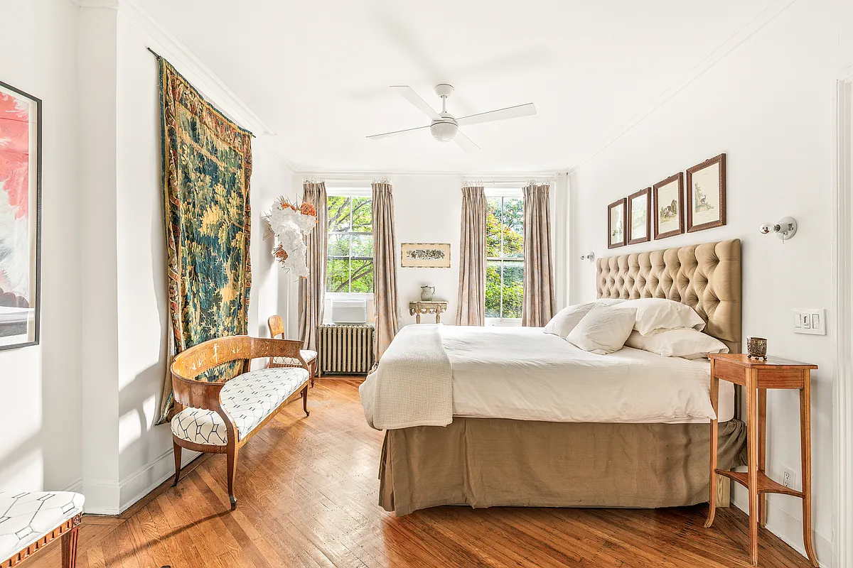 bedroom with wood floor, white walls, ceiling fan