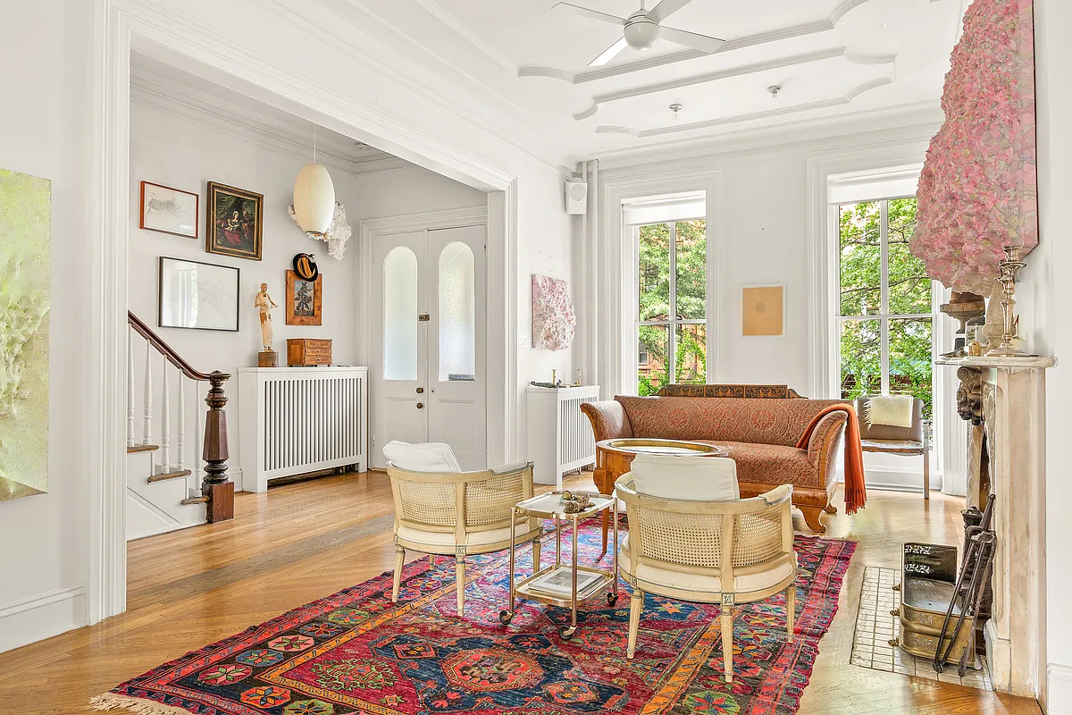 parlor with wood floor, marble mantel, stair with newel post