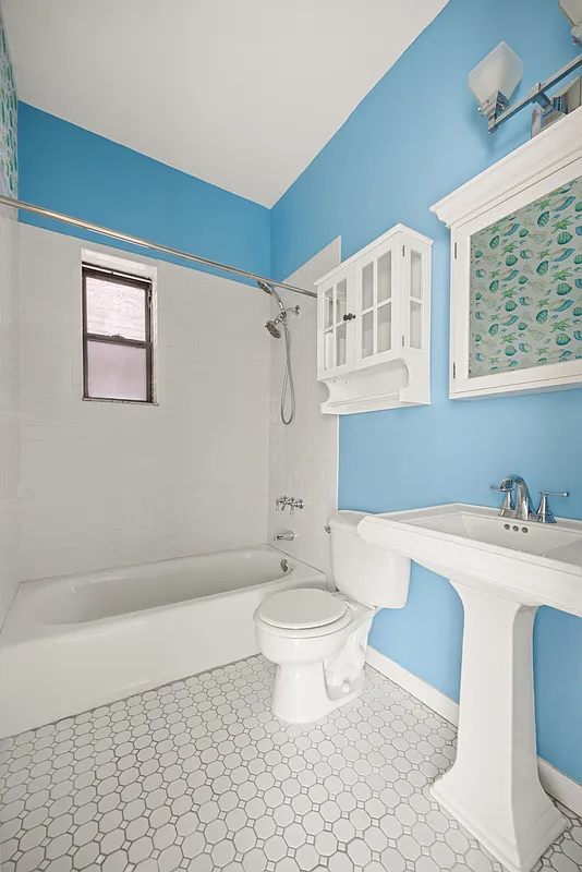 bathroom with white fixtures and tile and blue painted walls