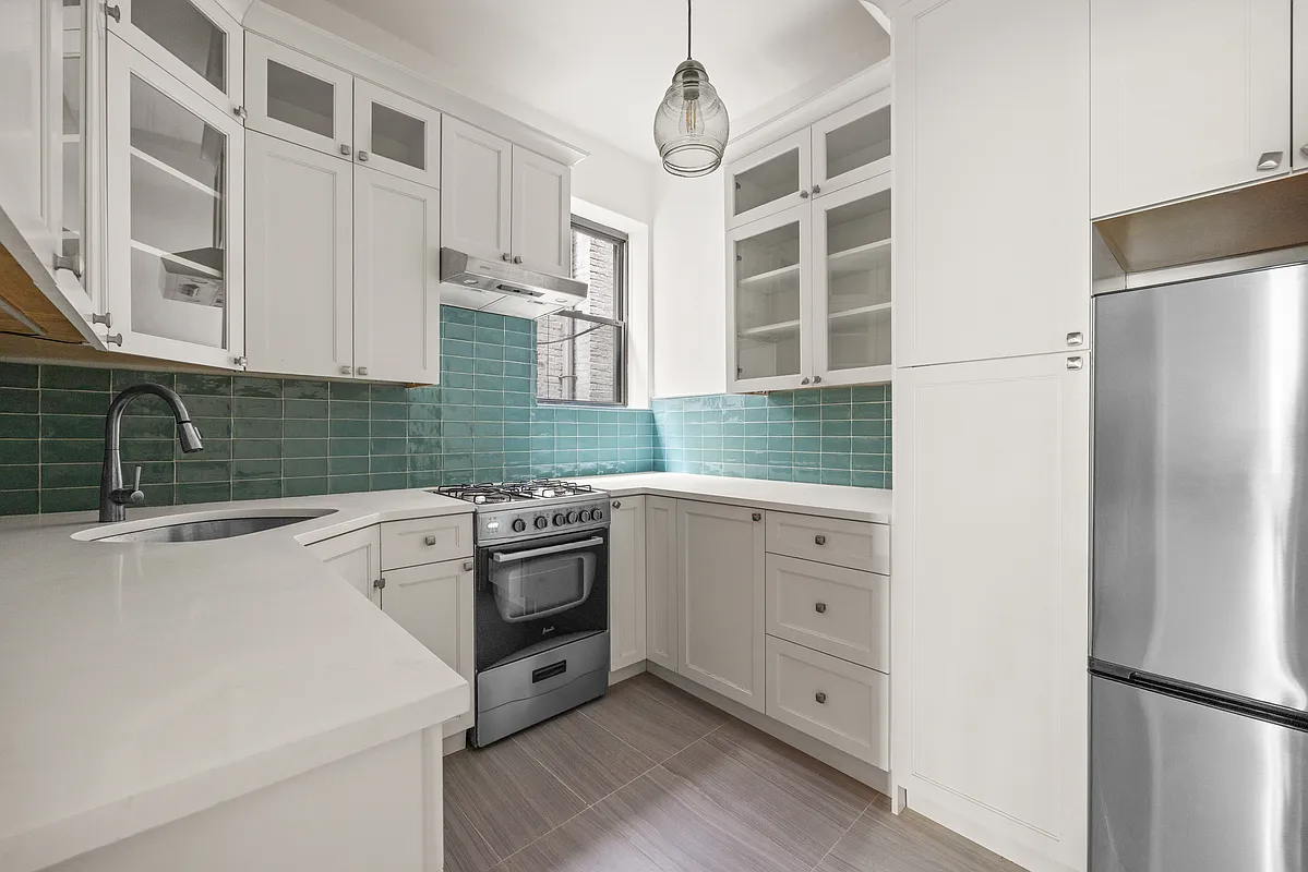 kitchen with white cabinets, blue tile backsplash