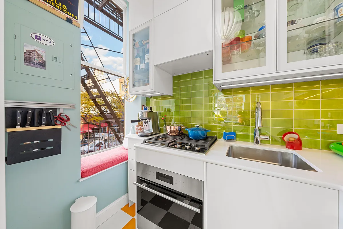 kitchen with white cabinets and bright green backsplash