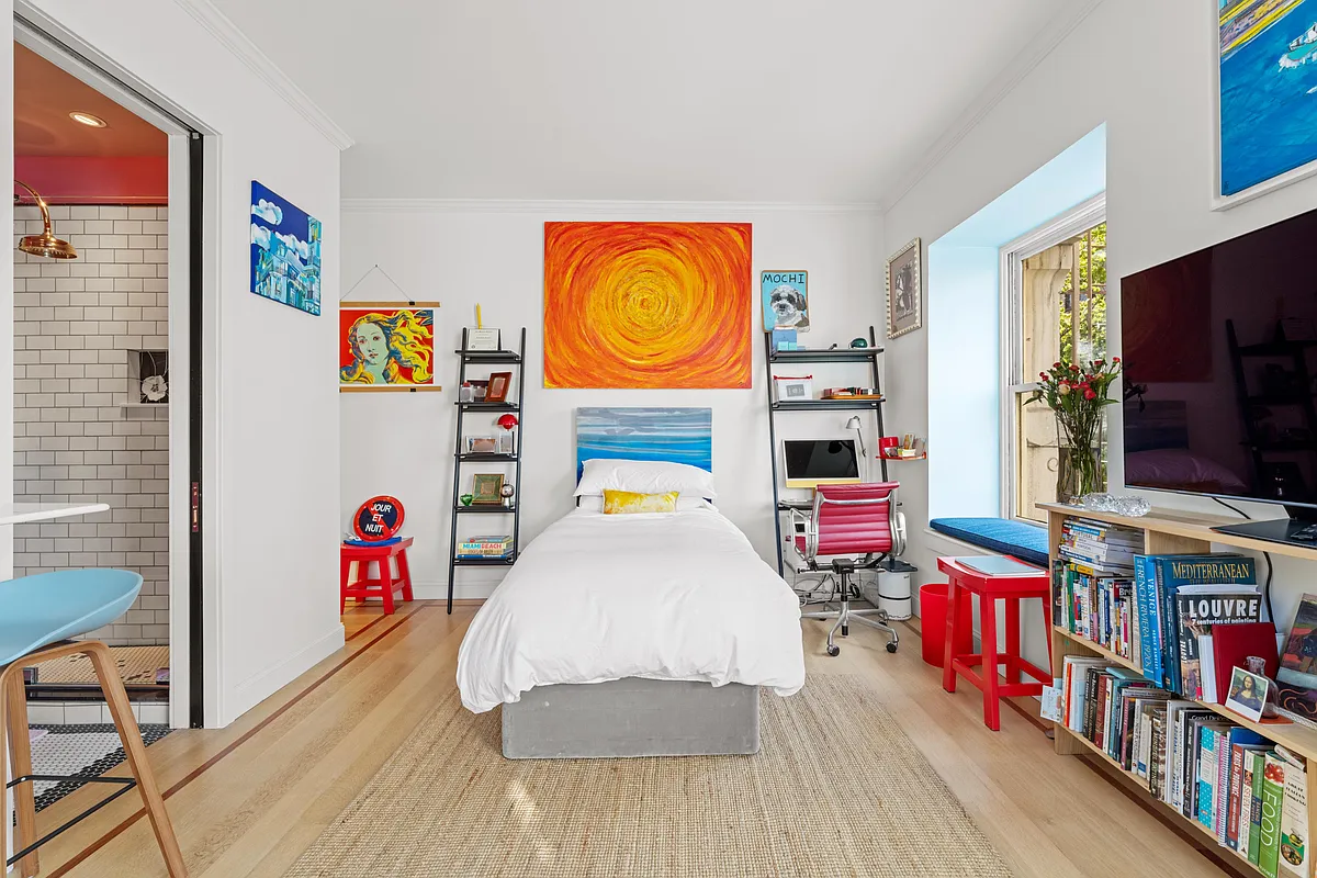 living space with white walls and view into bathroom with white subway tile