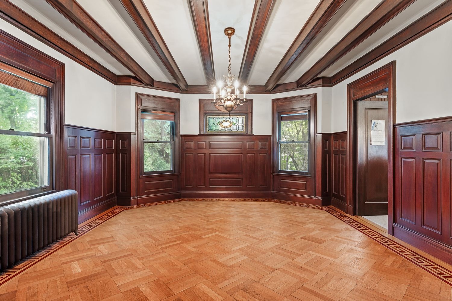 dining room with wainscoting, beamed ceiling, and stained glass