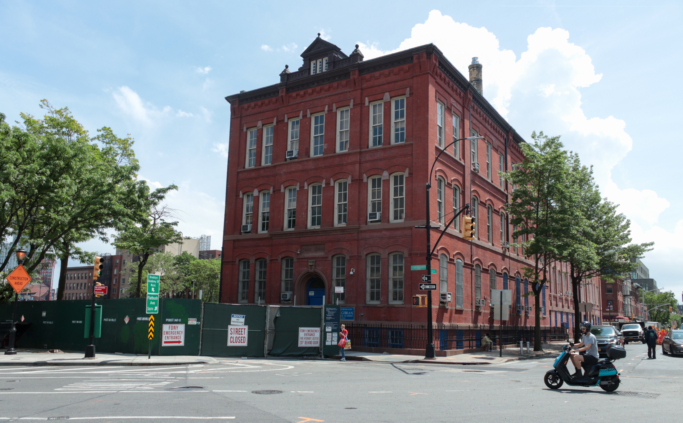 brick school building with a construction fence