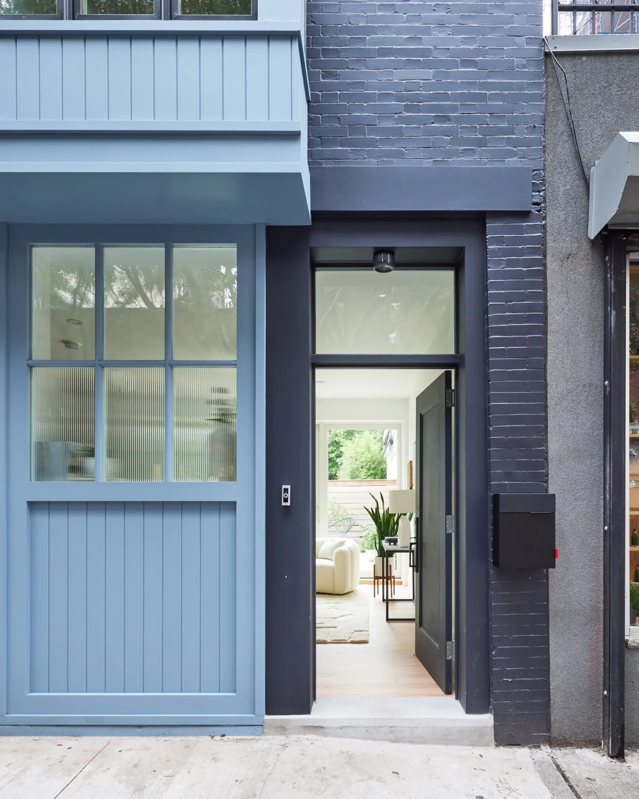EXTERIOR - open front door of blue carriage house