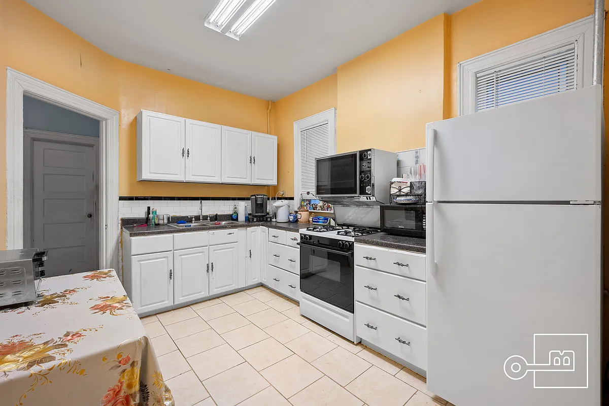 kitchen with white cabinets, beige floor tile