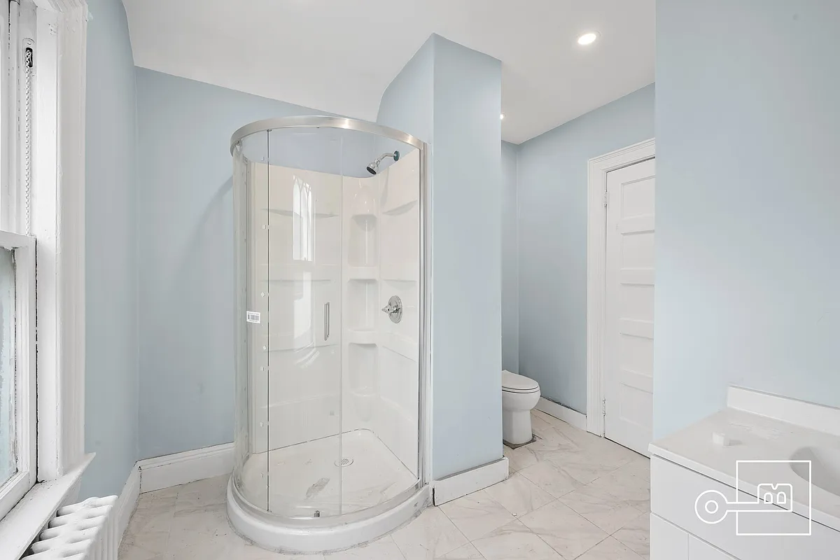 bathroom with curved shower stall, recessed lighting