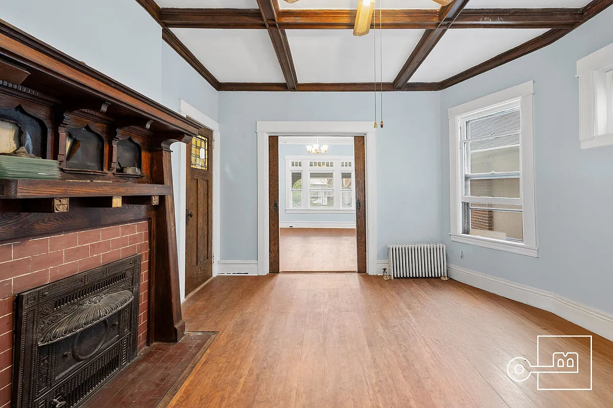 parlor with arts and crafts mantel, stained glass windows in doors and a beamed ceiling