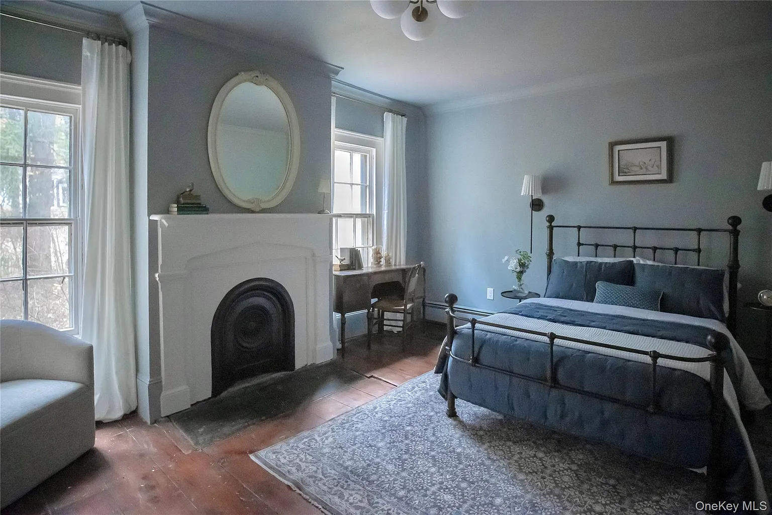 bedroom with marble mantel, wood floor