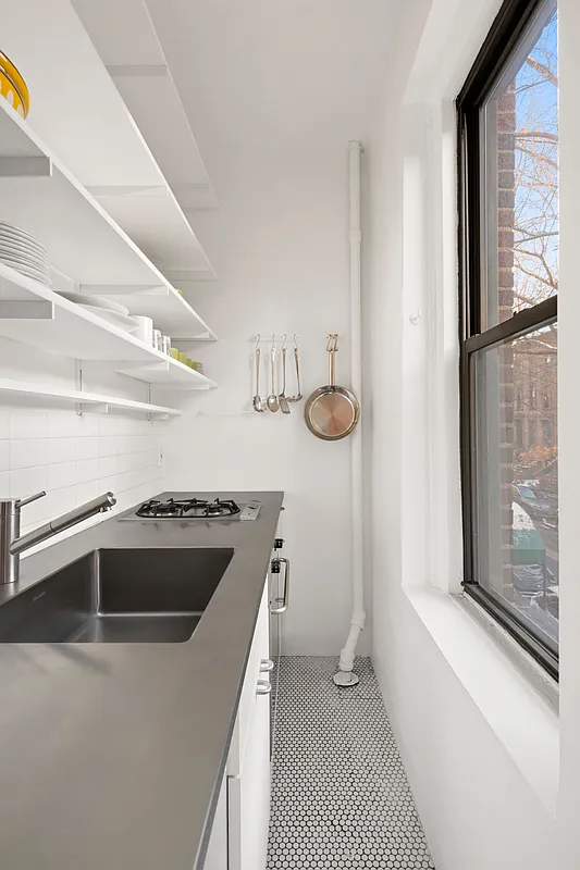 windowed kitchen with penny tile floor, open shelving