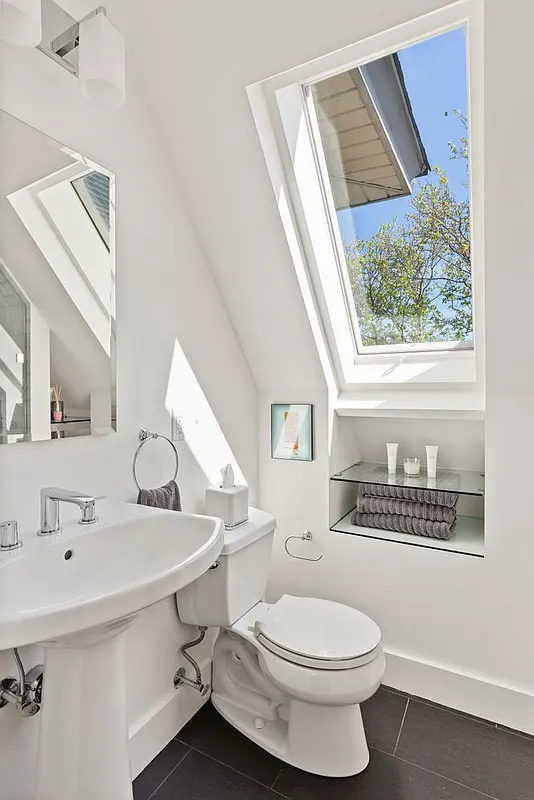 bathroom with skylight, white fixtures