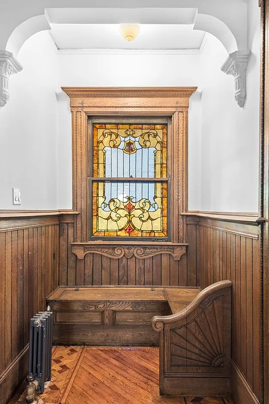 niche with wainscoting, a built-in bench and stained glass