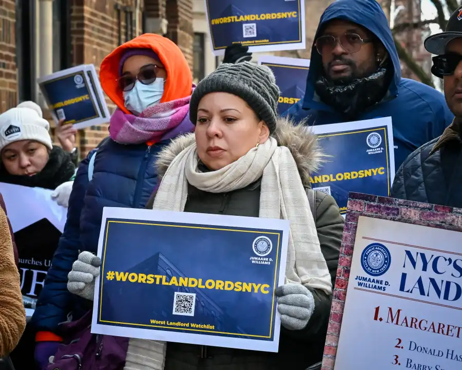 people in crowd hold a worst landlords sign