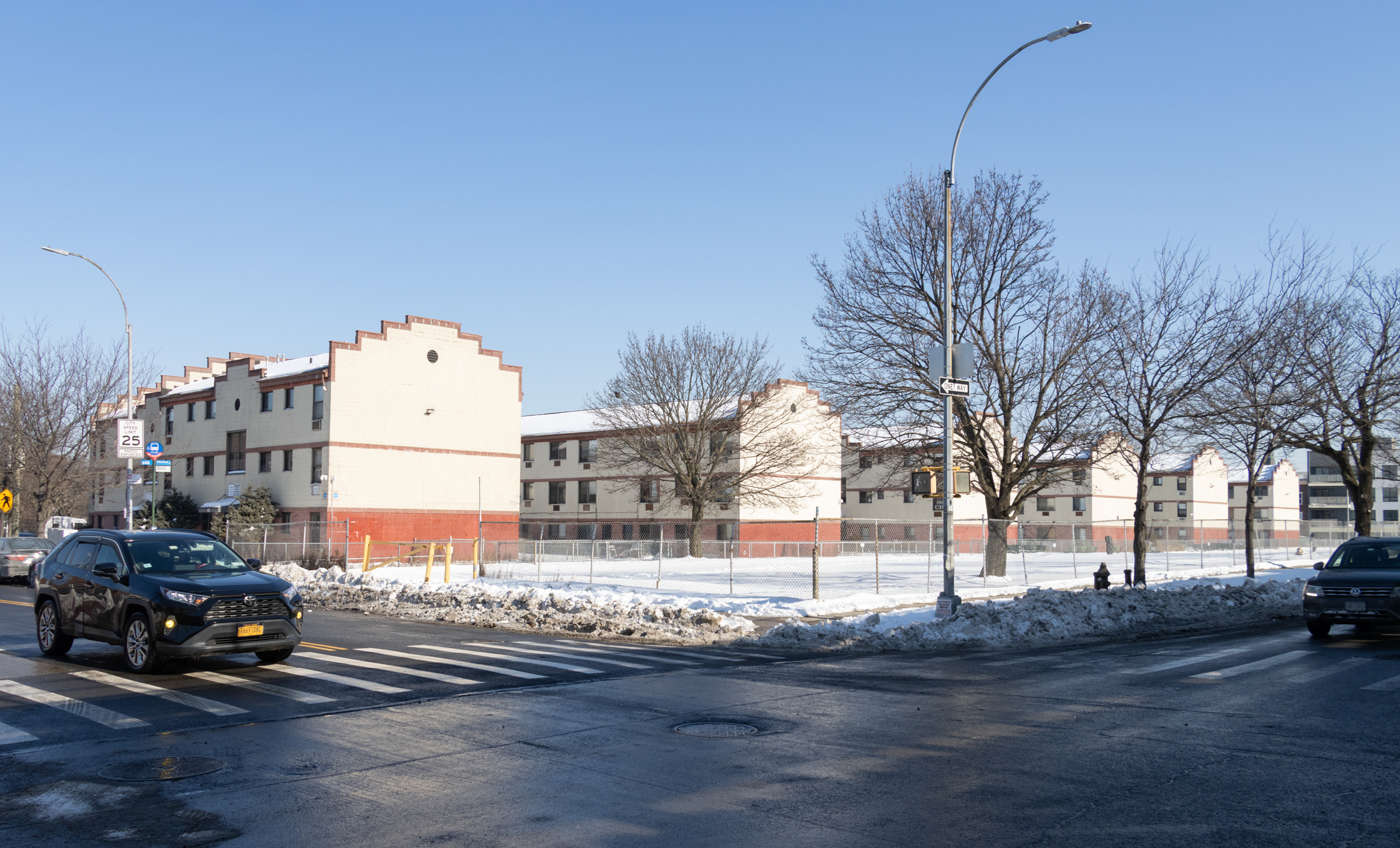 low scale housing and a fenced off parking lot viewed from the corner of Atlantic and Utica