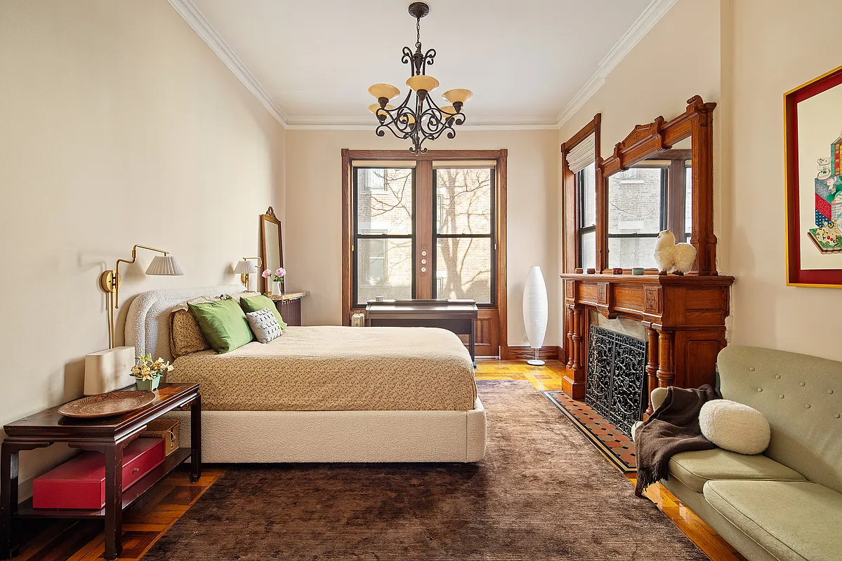 bedroom with a wood mantel with mirror, wood floor