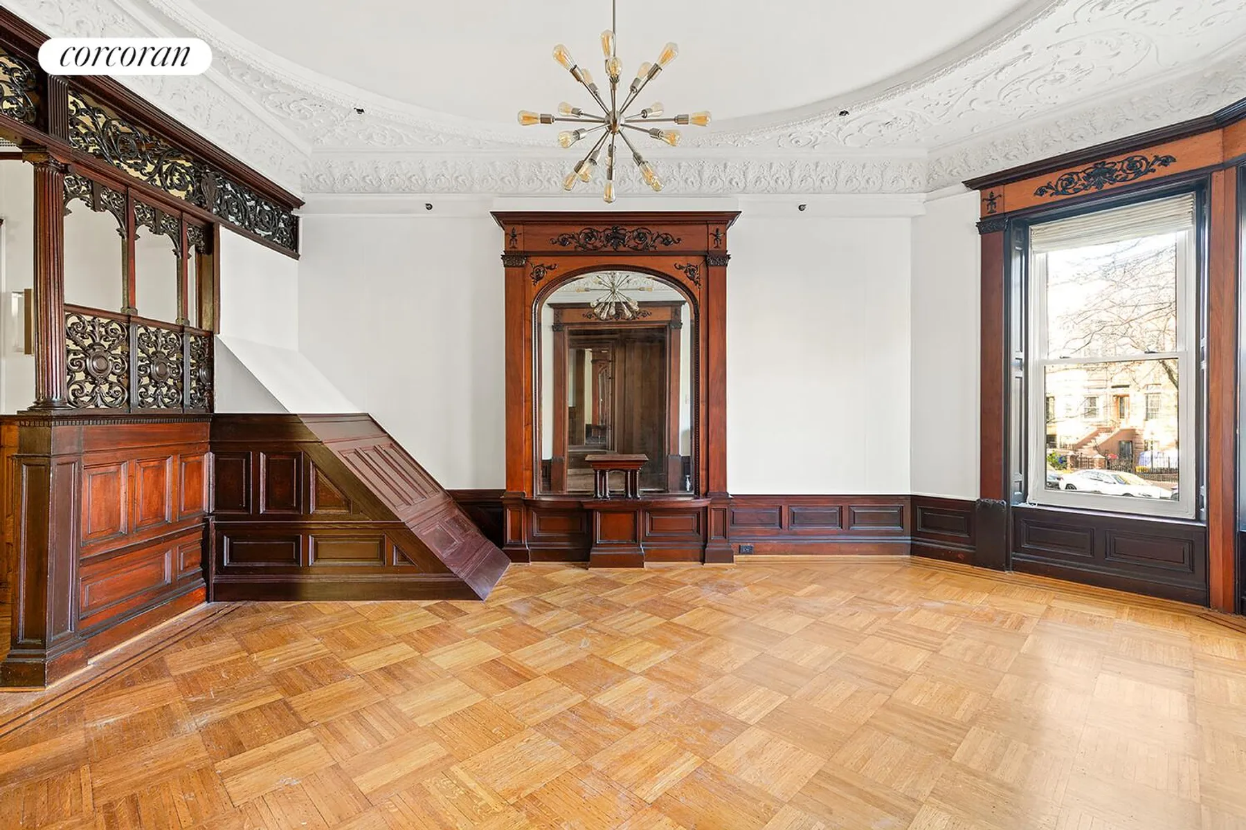 parlor with wainscoting, plasterwork, fretwork, wood floor