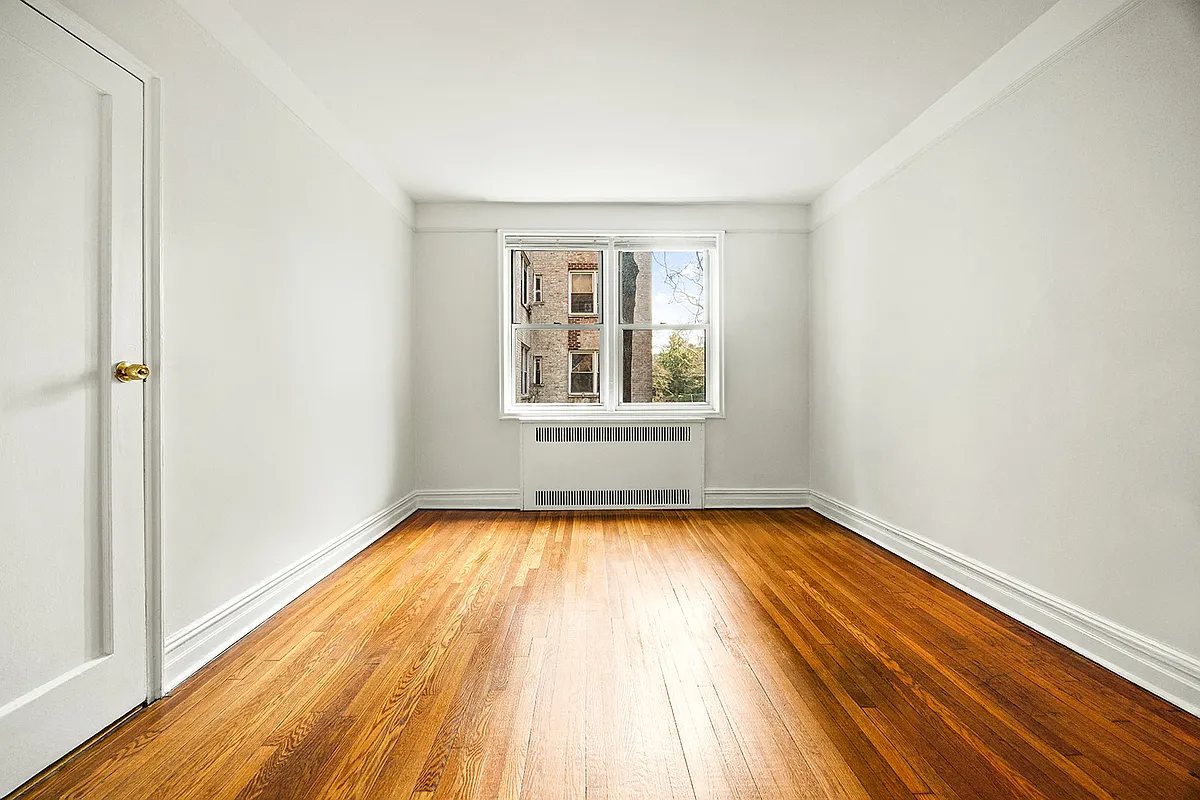 bedroom with white walls, wood floor