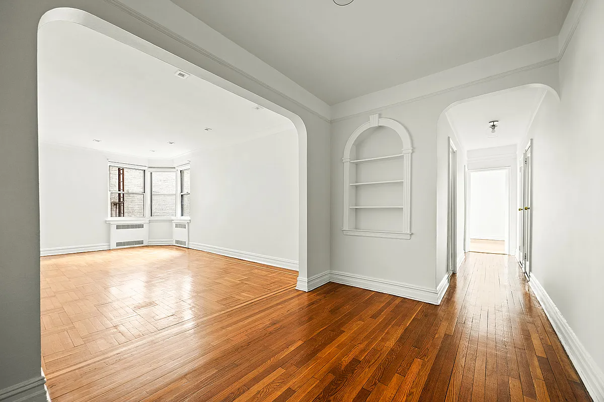 foyer with a view into a living room with wood floor and white walls