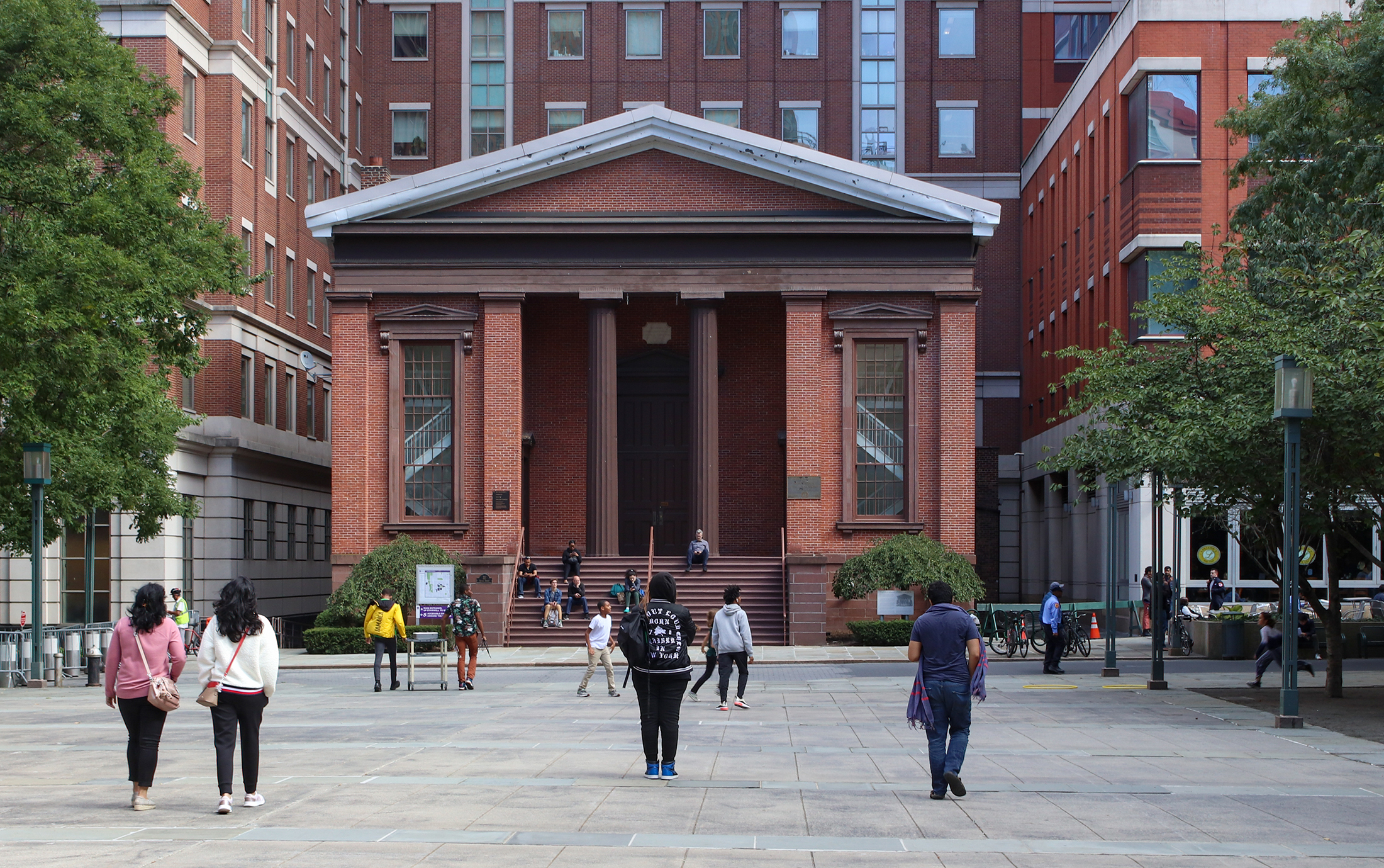 people walking in front of a temple front building