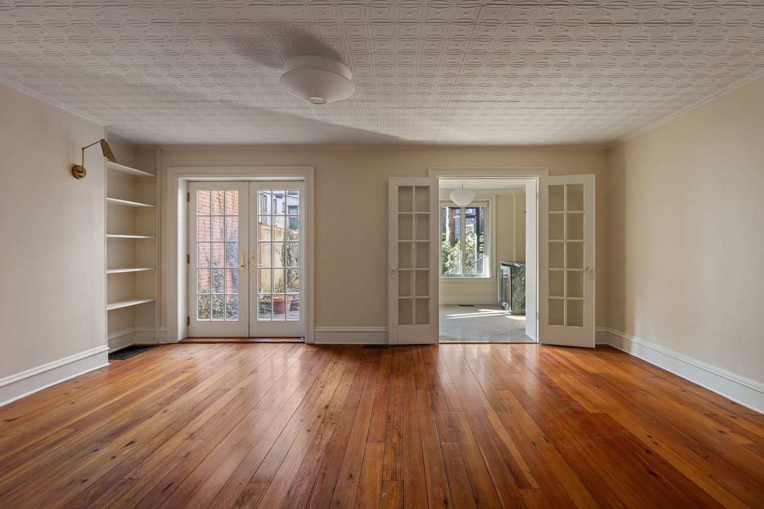 garden level living room with french doors, tin ceiling