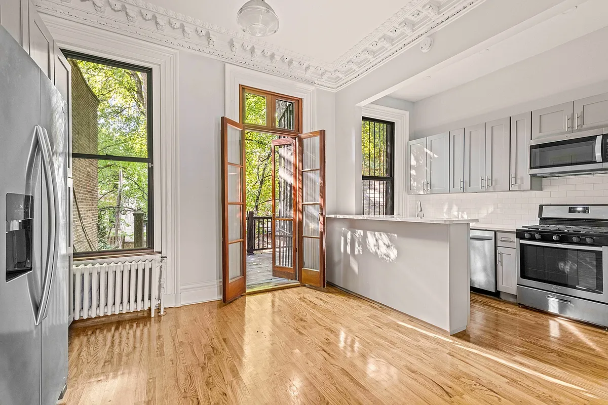 rear parlor with kitchen with gray cabinets