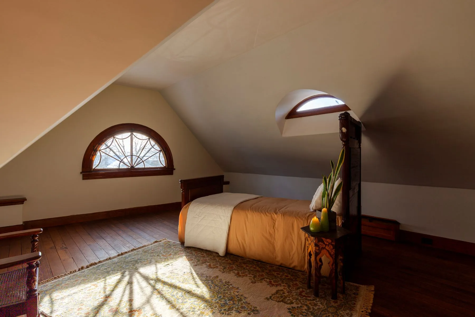 attic bedroom with fanlight window, wood floor