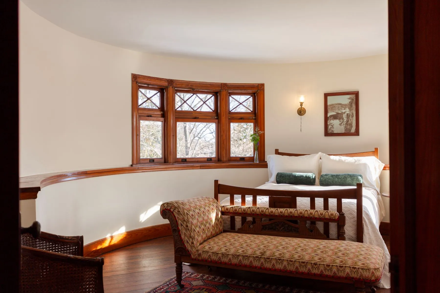 bedroom with curved wall, wood floor