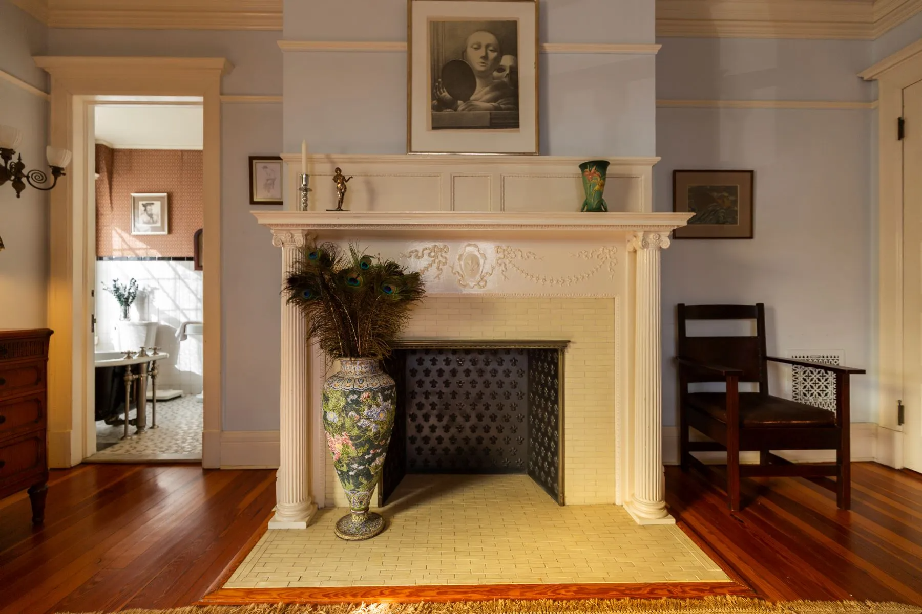 bedroom with mantel, view into en suite bath with claw foot tub