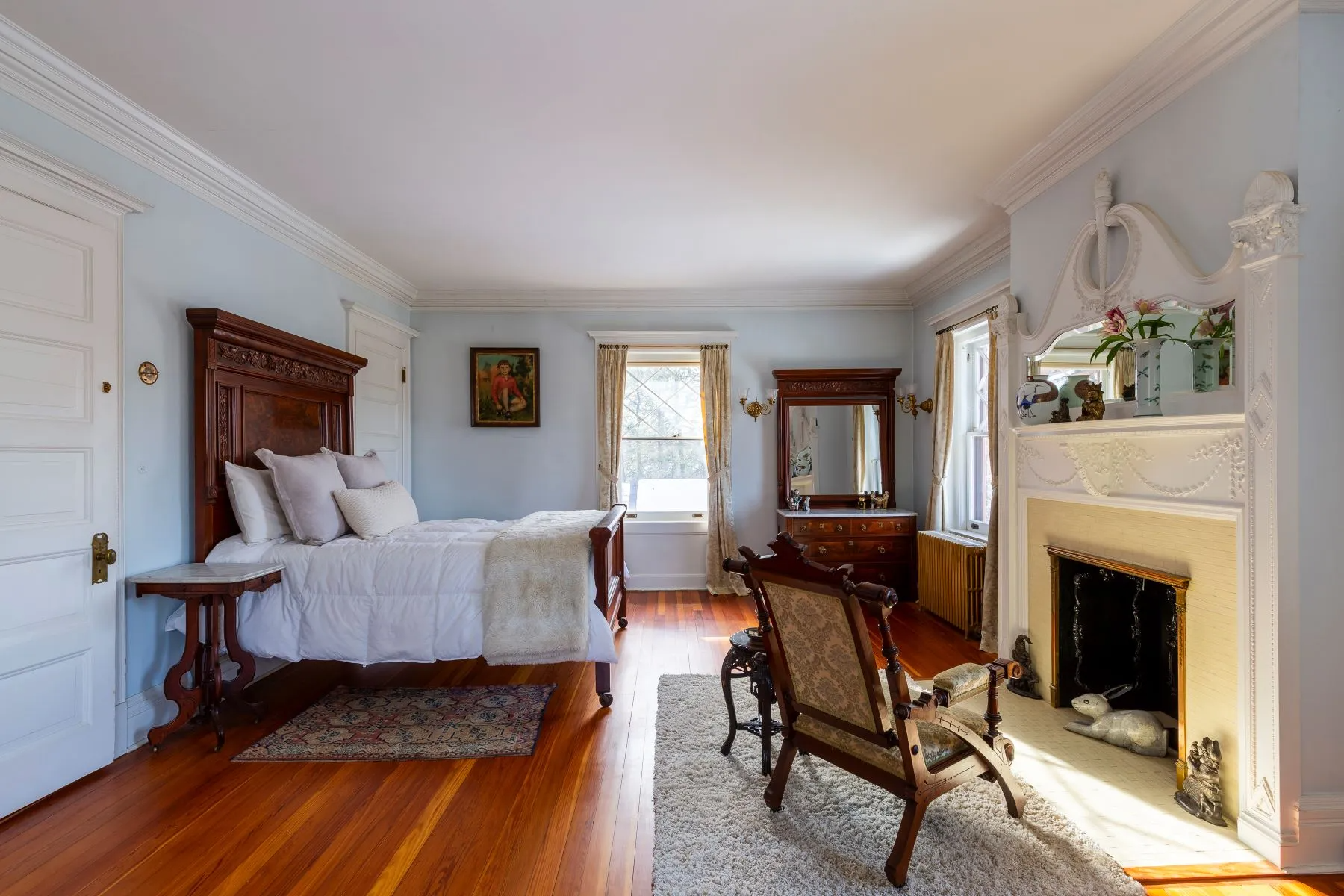 bedroom with mantel, wood floor