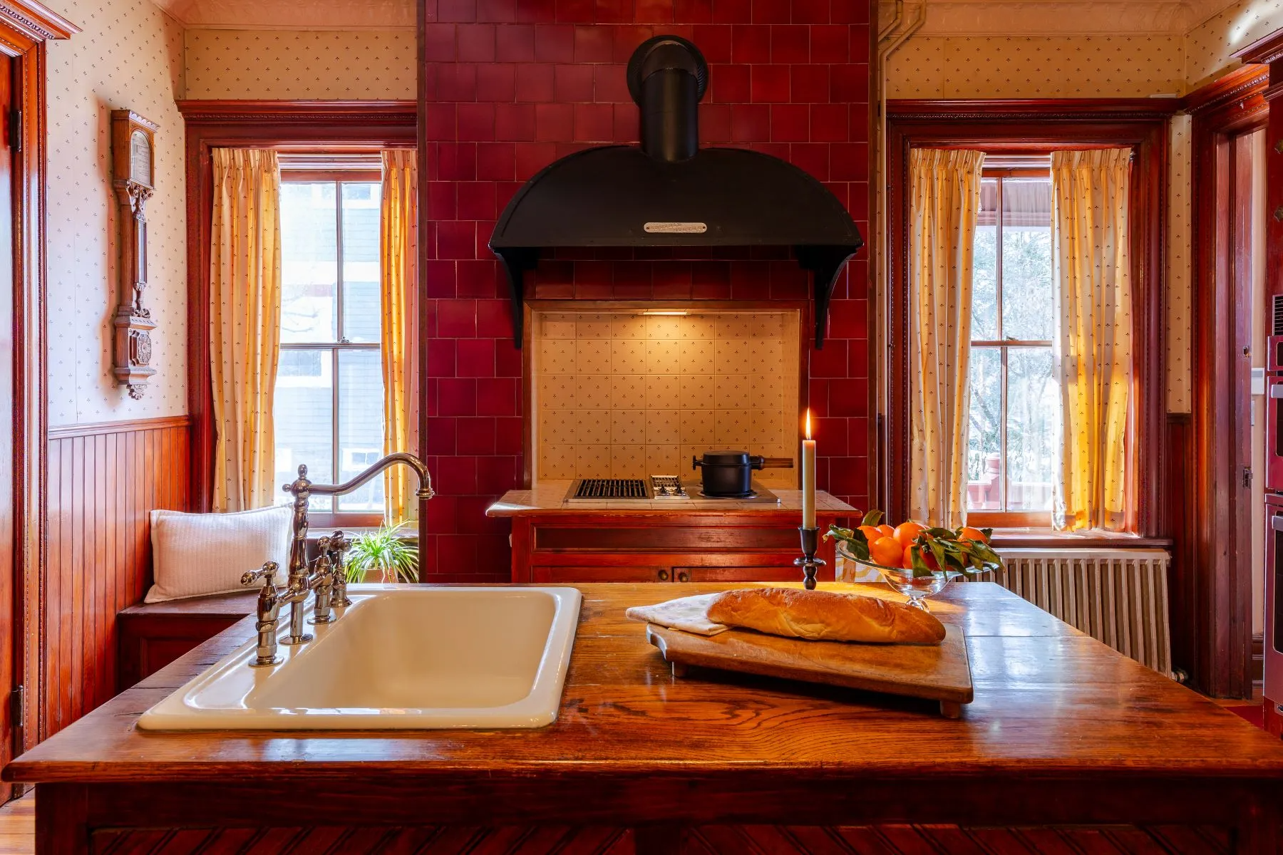 kitchen with wood-topped island, wainscoting, modern stovetop